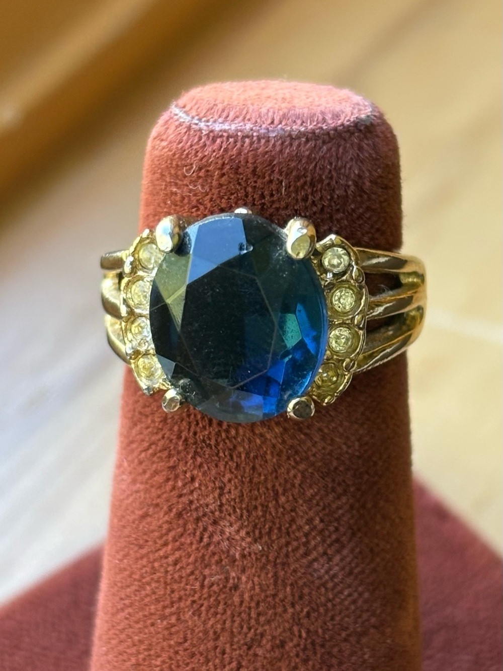 Gold Tone Ring with Deep Blue Oval Gem and Accent Stones